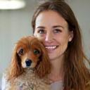 Jessica Taylor, Lead Groomer, smiling with a cocker spaniel
